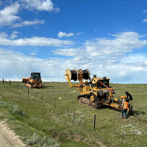 A field featuring a tractor and a bulldozer, showcasing Victory Equity Construction's equipment in action.
